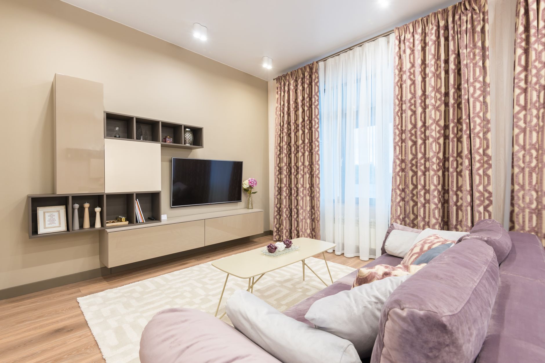 Apartment living room with floral curtains and warm neutral color palette