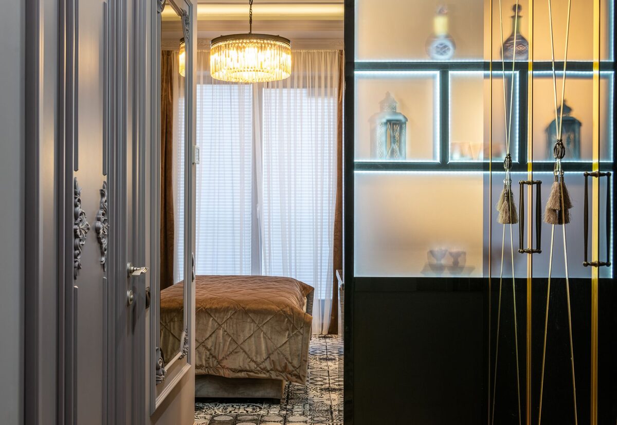 small bedroom with mirror and tall curtains to make the room look bigger