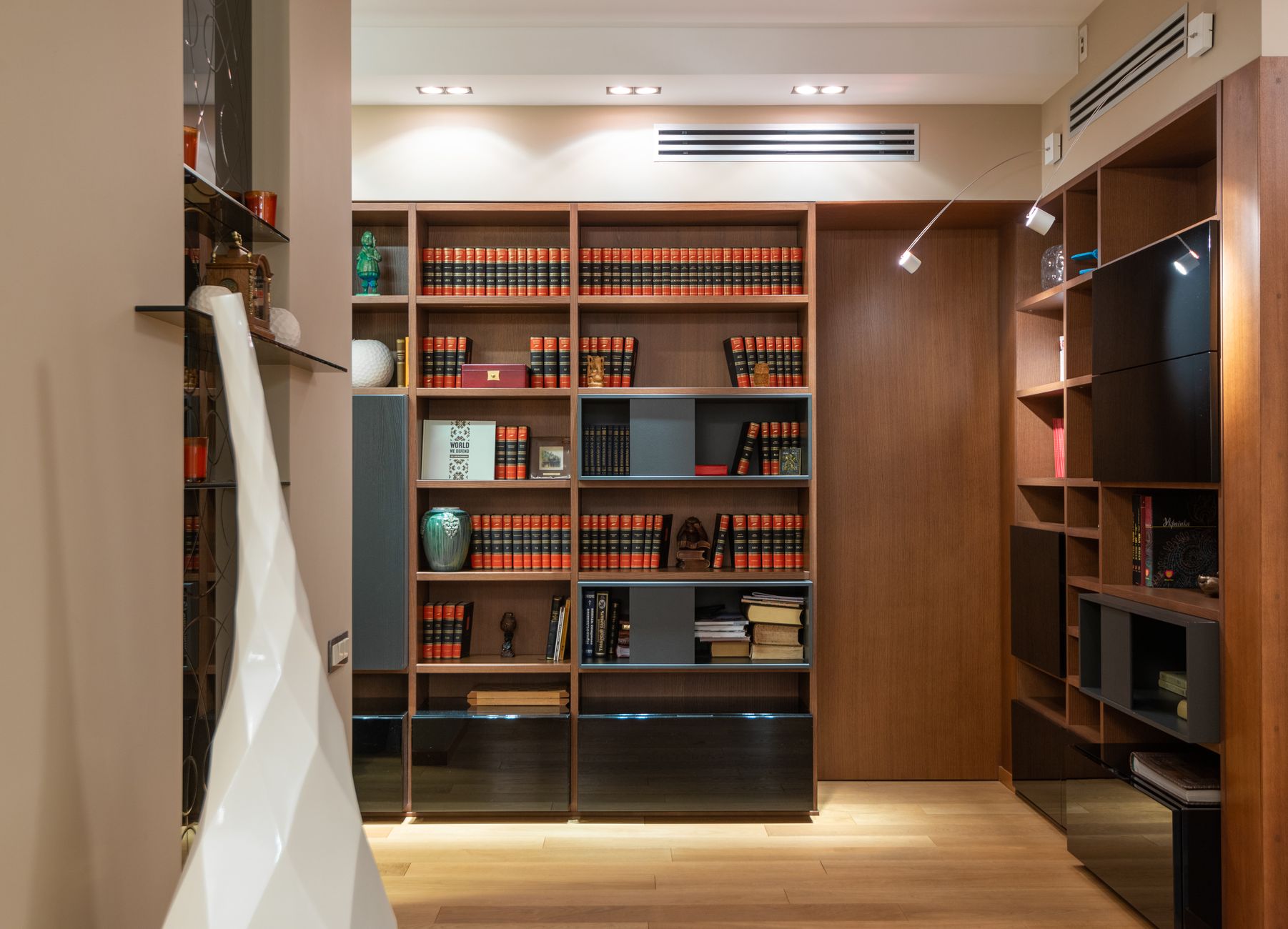 Tall wooden bookshelf used as room divider between living and bedroom zones