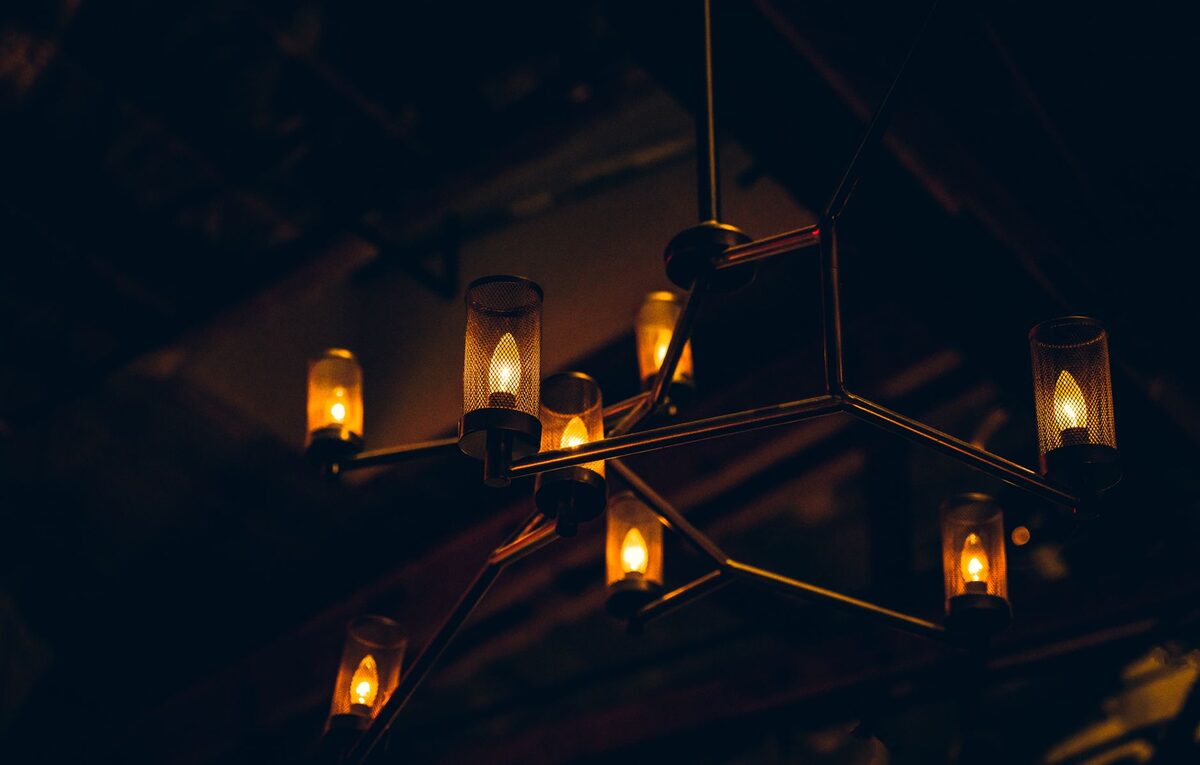 Cozy dark apartment interior with layered warm lighting creating a moody atmosphere