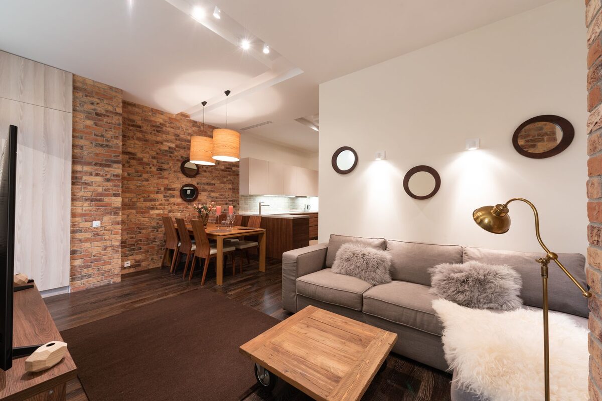 Apartment living room with warm floor lamp creating layered lighting in a dark space