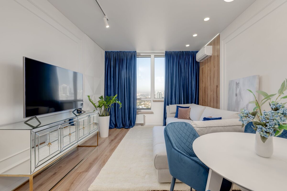 Large leaning floor mirror in a dark apartment reflecting light to make the room feel brighter