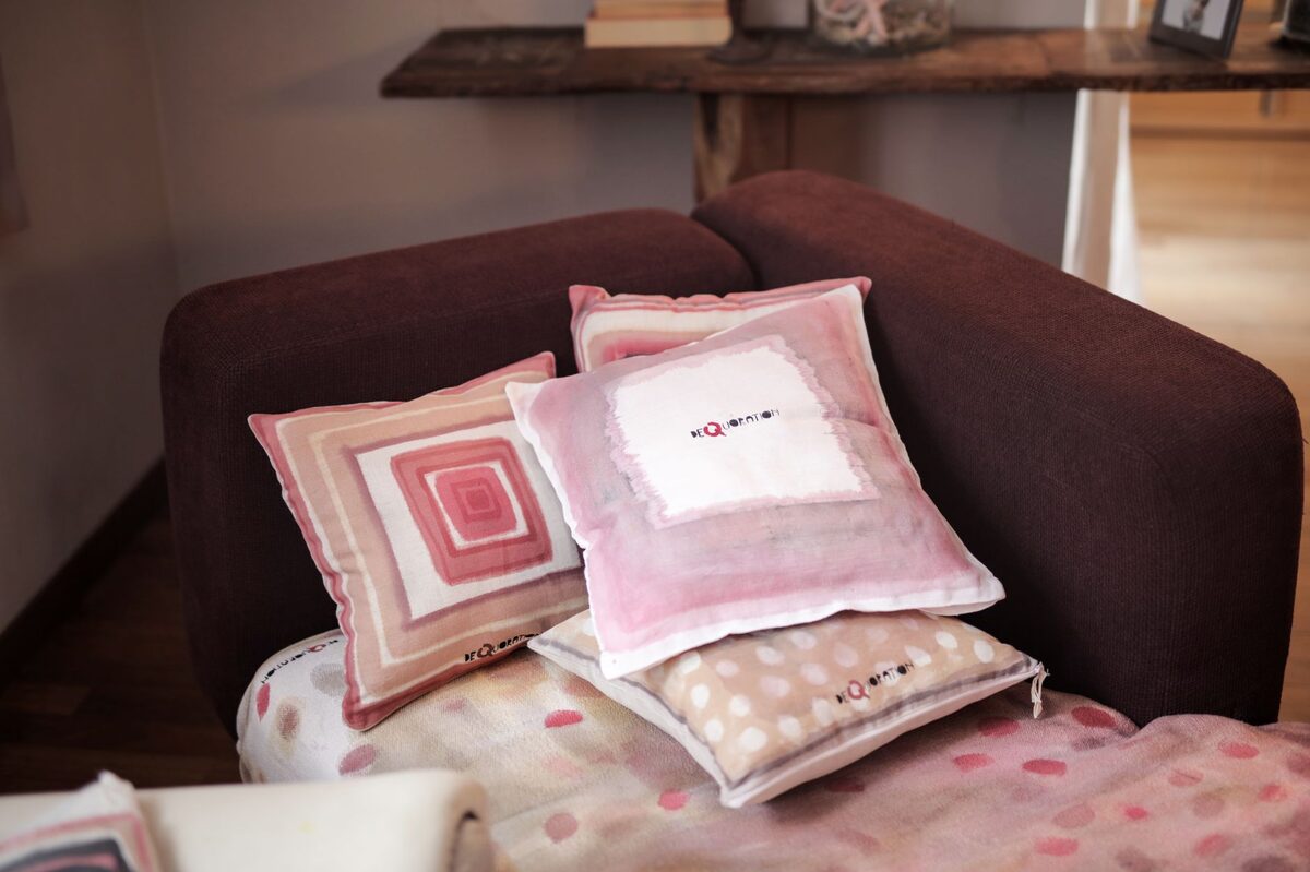 Cozy apartment sofa with warm linen throw pillows and chunky knit blanket adding texture and warmth