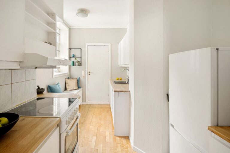 Bright modern apartment kitchen interior with white cabinets
